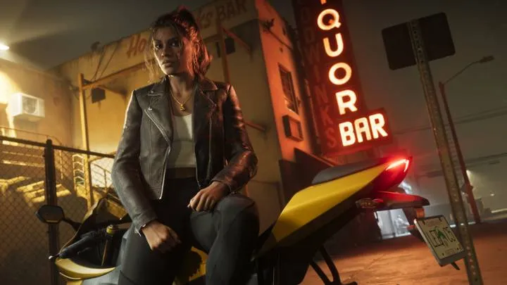 Лусия Каминос — В кожаной куртке на мотоцикле у неоновой вывески LIQUOR BAR.